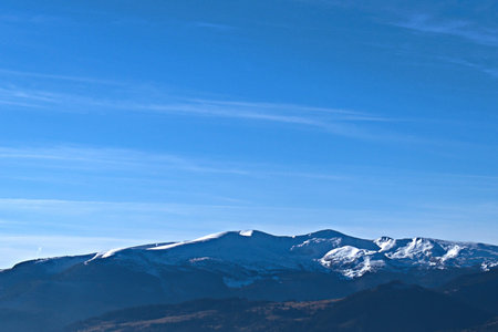 Snowy mountain peaks in sunlight against blue sky background