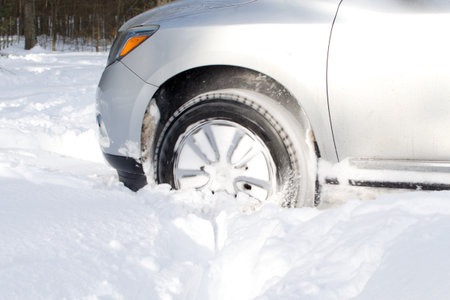 blurred motion of front wheel of vehicle driving on snow winter roadの写真素材