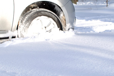 blurred motion of front wheel of vehicle driving on snow winter road