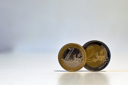 1 and 2 euro close up on neutral blurred background with place for text