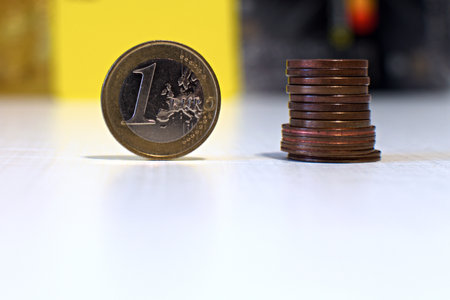 one euro coin close up and stack of cents on blurred colorful backgroundの写真素材