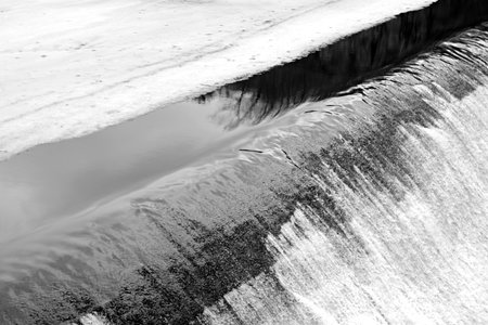 melting ice on river turns into stormy stream of falling water