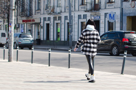 Ukraine Zhytomyr March 30, 2021. Girl in fashion plaid jacket on background of old town street
