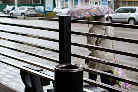 Blurred background of urban city street on rainy day through metal fence of outdoor cafe. Ukraine Zhytomyr April 21, 2021のeditorial素材