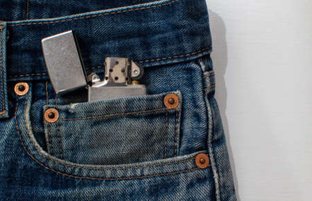 Metal lighter close up in denim pocket on white backgroundの写真素材