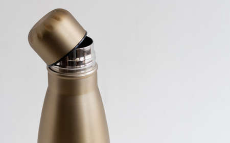 Open cap of metal bottle close-up on white backgroundの写真素材