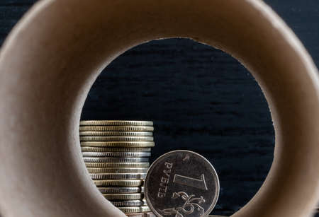 1 russian ruble coin close-up on black background inside blurred paper pipe backgroundの写真素材