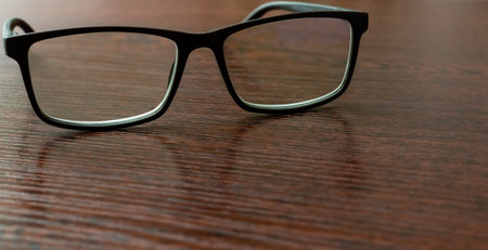Stylish eyeglasses on office table close-up on blurred backgroundの写真素材