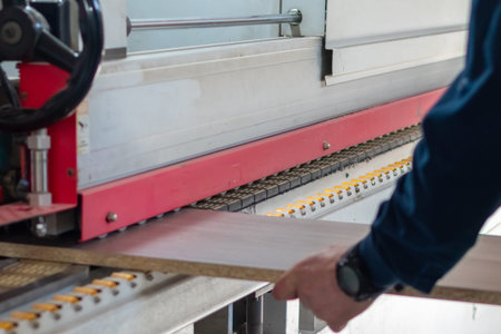 Furniture manufacturing. Gluing strips of edges on wood boards on special machine in production of...