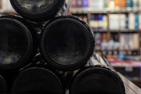 Wine bottles stacked on side on blurred liquor store background