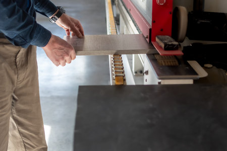 Furniture manufacturing. Gluing strips of edges on wood boards on special machine in production of...