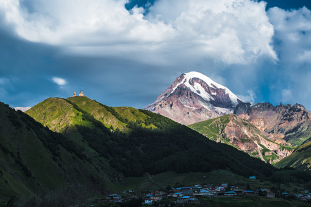 Mount Kazbek view from Stepantsminda town in Georgia in good weather for climbing. It is a dormant stratovolcano and one of the major mountains of the Caucasus.の写真素材