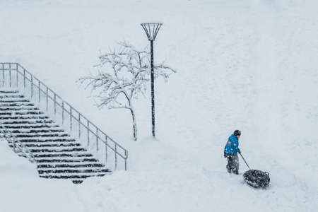 MOSCOW, RUSSIA - FEBRUARY 13, 2019: Small boy snow tubing a snowfall.のeditorial素材