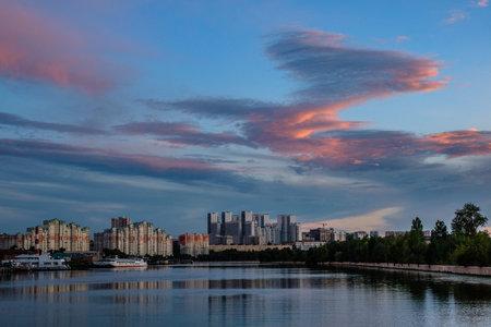 MOSCOW, RUSSIA - AUGUST 5, 2018: View of modern buildings near the water during sunset.