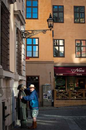 STOCKHOLM, SWEDEN - OCTOBER 3 2021: A man hugs a monumentのeditorial素材