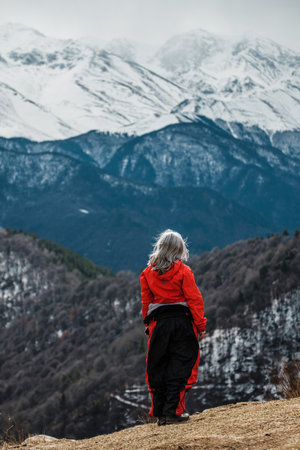 VERKHNYAYA TEBERDA, RUSSIA - MARCH 12 2023: A girl stands on the edge of a plateauのeditorial素材