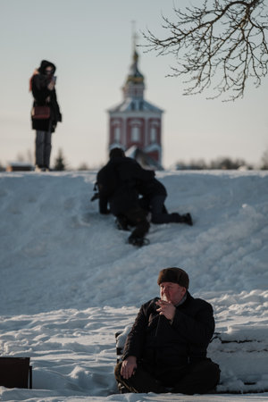 SUZDAL, RUSSIA - JANUARY 6 2023: A man smokes in front of the Boris and Gleb Churchのeditorial素材