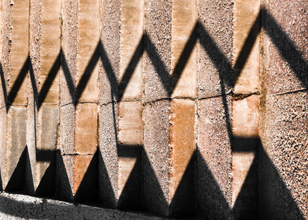Brightly lit concrete staircase with shadows from the railing. Horizontal frame.