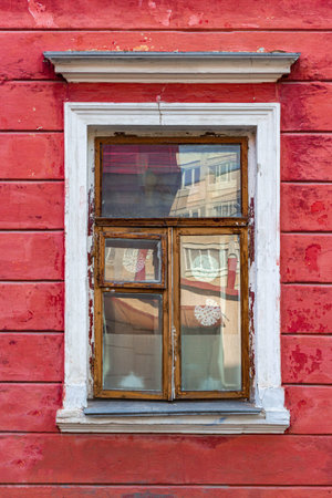 Old wooden window in a town house. Vertical frame.