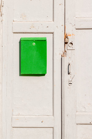 Green box on a brown wooden old door. Nastalgia. vertical frame.の写真素材