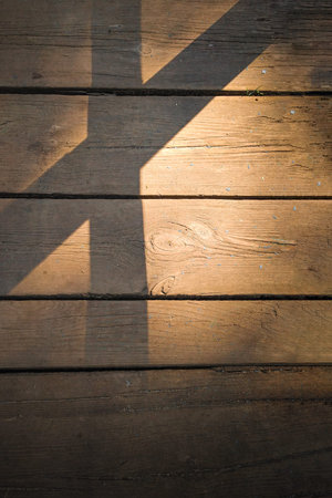 Wooden background of an old board in the evening light with shadows. Texture with place for text.の写真素材