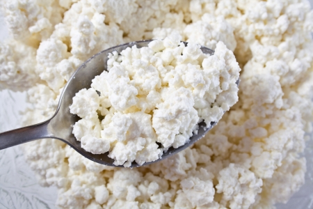 Cottage cheese clods and spoon. Macro image.の写真素材