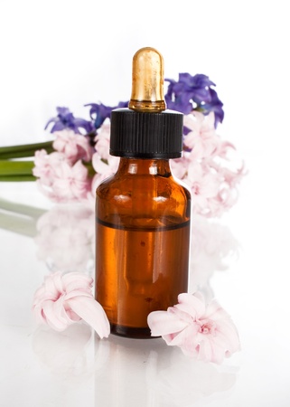 hyacinth flower leaf sprigs with an aromatherapy essential oil dropper bottle, isolated over white background の写真素材