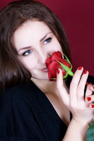 Beautiful woman enjoys the scent of red rosesの写真素材