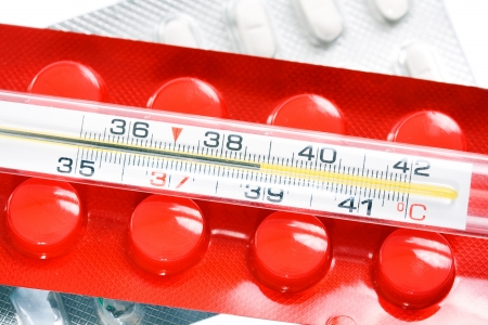 Isolated thermometer and pills on white backgroundの写真素材