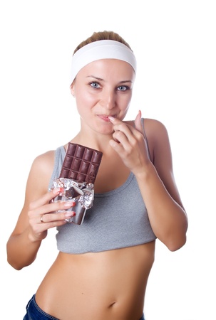 Portrait of young happy smiling woman eating chocolate isolatedの写真素材