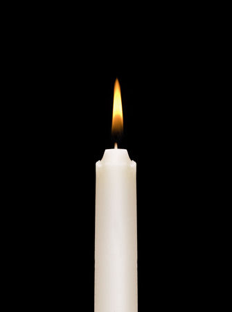 A burning white candle on a black .の写真素材
