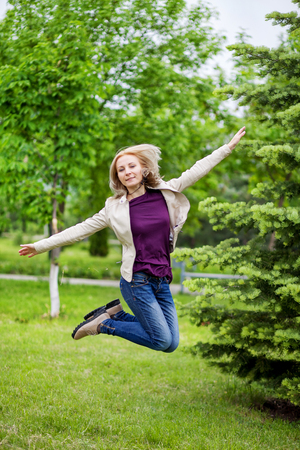 Woman jumping on path from the back.の写真素材
