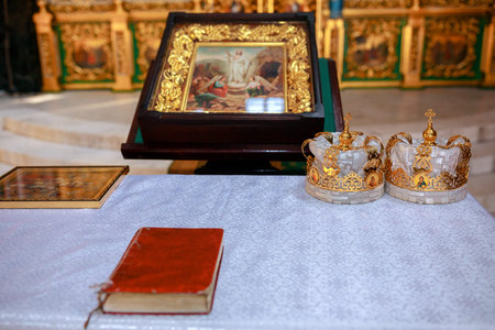 Golden crowns and bible and wedding ring on altar in church at wedding matrimony. traditional...