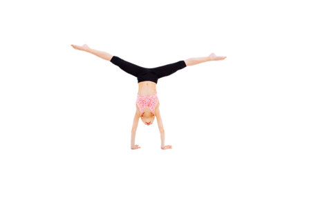 Slim pretty young girl athlete with hair combed into a ball is on your hands and do the splits.