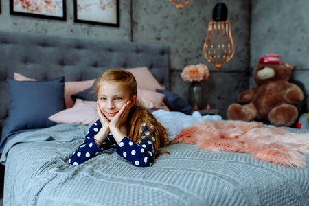 Beautiful girl smiling lying on the bedの写真素材