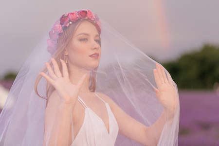 Beautiful woman admires a bouquet of lavender in a sunset, lavender fieldの写真素材