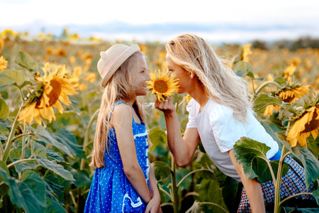 Mom and daughter are hiding behind a flower of a sunflowerの写真素材