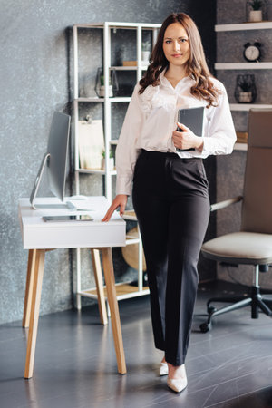 Beautiful woman standing with diary in hands, concept business lady, boss, secretaryの写真素材