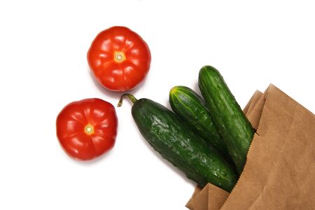 fresh vegetables tomatoes and cucumbers on a white backgroundの写真素材