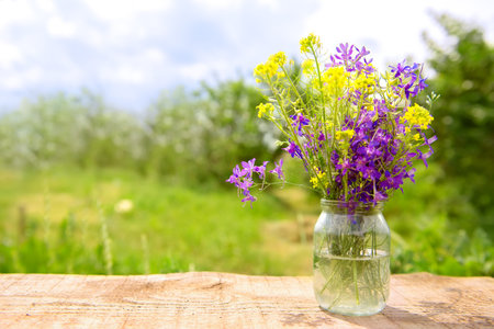 A bouquet of wild flowers in a jar in the open airの写真素材