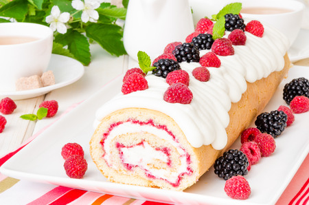 Vanilla roulade with raspberry jam and butter cream on a white backgroundの写真素材
