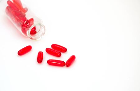 Medicine red pills or capsules on white background with copy space.の写真素材