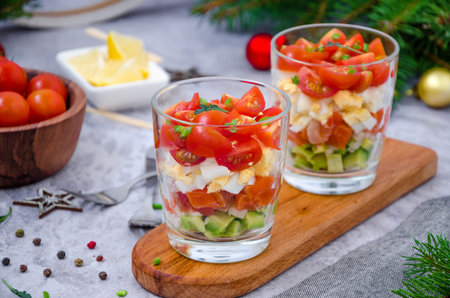 Portion salad with smoked salmon, avocado, egg, cherry tomatoes with cream cheese dressing in a...