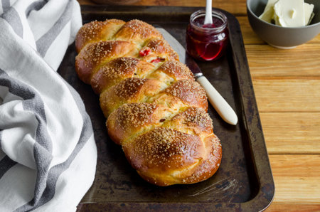 Traditional sweet Easter bread with raisins, dried cherries on an old baking tray jam and butter....