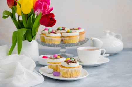 Homemade Easter vanilla cupcakes bird's nest with butter cream, chocolate and candy eggs on a dish....