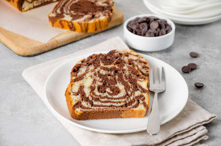 Loaf of marble pound cake on a board on a gray concrete background. Copy spaceの写真素材