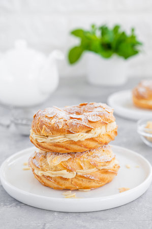 French traditional cake Paris Brest with praline cream, powdered sugar and almond petals on top on a...