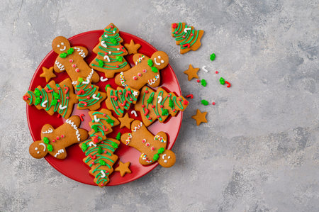 Gingerbread cookies in the form of man and christmas trees decorated with sugar glaze and sprinkled...