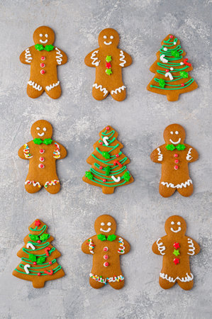 Christmas or New Year food background. Gingerbread cookies decorated with sugar glaze on a gray...