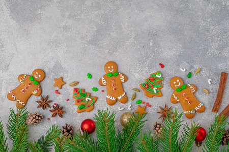 Christmas or New Year food background. Gingerbread cookies decorated sugar glaze with cinnamon sticks, cardamom and anise on a gray concrete background. Copy space, top viewの写真素材